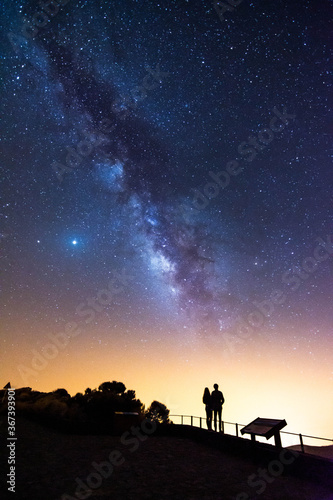 Silhouette of a couple looking at the stars and the Milky Way on a summer night in the sky of Tenerife © Iván Berrocal
