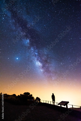 Silhouette of a man looking at the stars and the Milky Way on a summer night in the sky of Tenerife