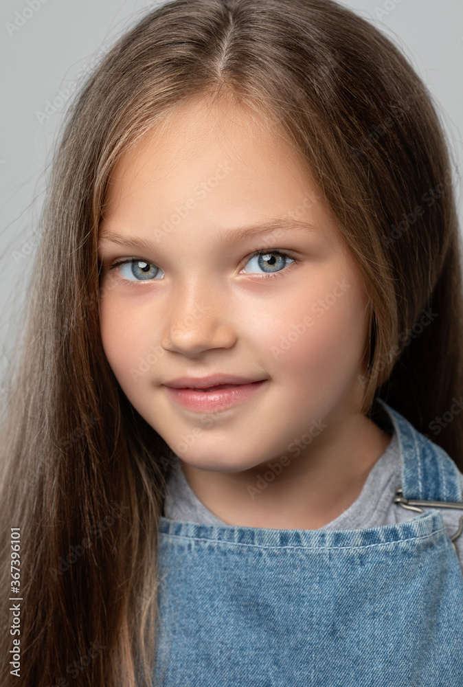 Portrait of a beautiful smiling girl with blue eyes, with light brown hair. She looks into the camera. Family concept. Portrait of a beautiful smiling girl with blue eyes, with light brown hair. She looks into the camera. Family concept.