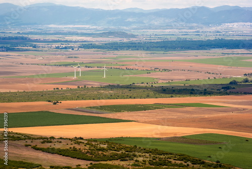 Landscape with fields, mountains and wind turbines