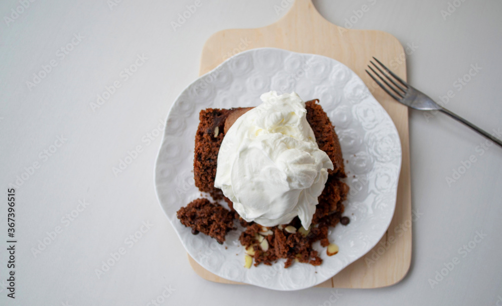 Composition on a gray background in natural sunlight. Homemade cake (chocolate sponge cake with whipped cream), top view. Composition on a gray background in natural sunlight. Homemade cake (chocolate sponge cake with whipped cream), top view.