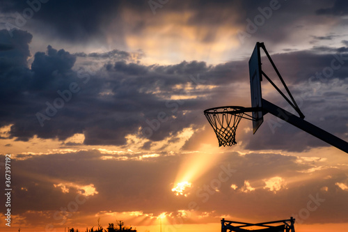 Sunrise behind a basketball court, the court located on the waterfront in Palermo, Sicily, Italy.