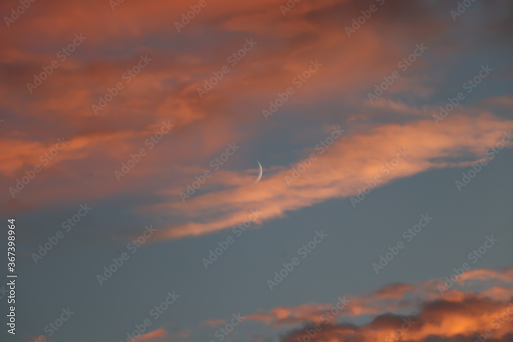 moon on a background of clouds and blue sky, sunset