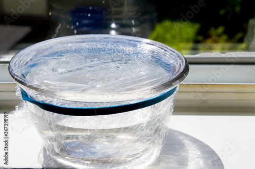 Simple experiment discovering the water cycle; Precipitation, evaporation and condensation in a covered bowl photo