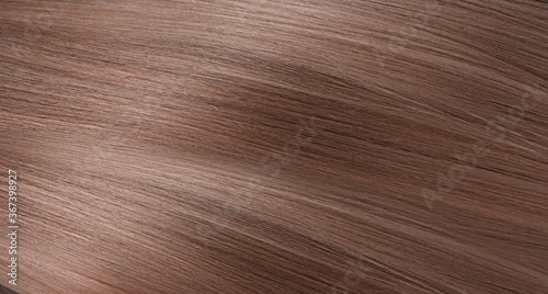 A closeup view of a bunch of shiny straight blond hair in a wavy curved style