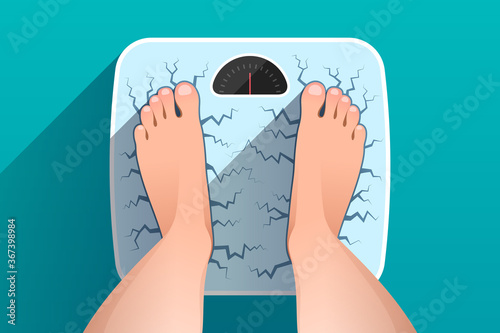 Top view of feet of woman standing on broken cracked weight scales