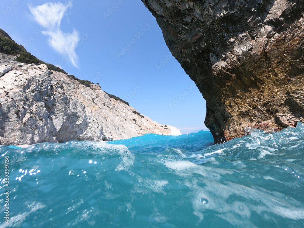 Sea level and underwater ultra wide photo of Lalaria beach, one of the most beautiful in Greece and one that made Skiathos island famous with arch like rock formation, Sporades islands