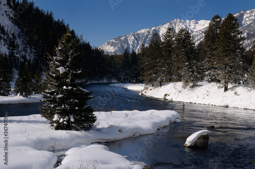 Men Wading on Madison River in winter fly fishing with snowy Rocky mountain Madison Range Montana photo