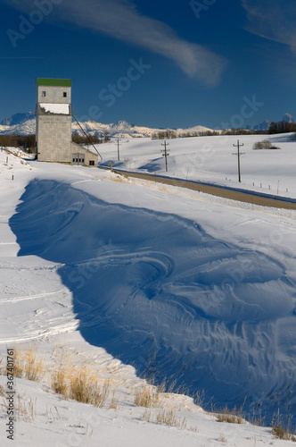 Snow drift off highway 32 at Pillsbury Mills Grain Elevator in Idaho in winter with Teton Range mountains