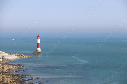 white and red lighthouse in the oceans and blue sky