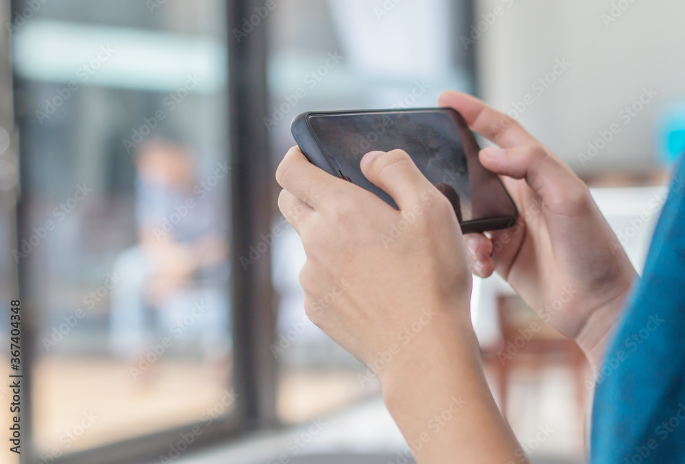 The boy is playing online games in his mobile phone, which is the technology age nowadays. The boy is playing online games in his mobile phone, which is the technology age nowadays.