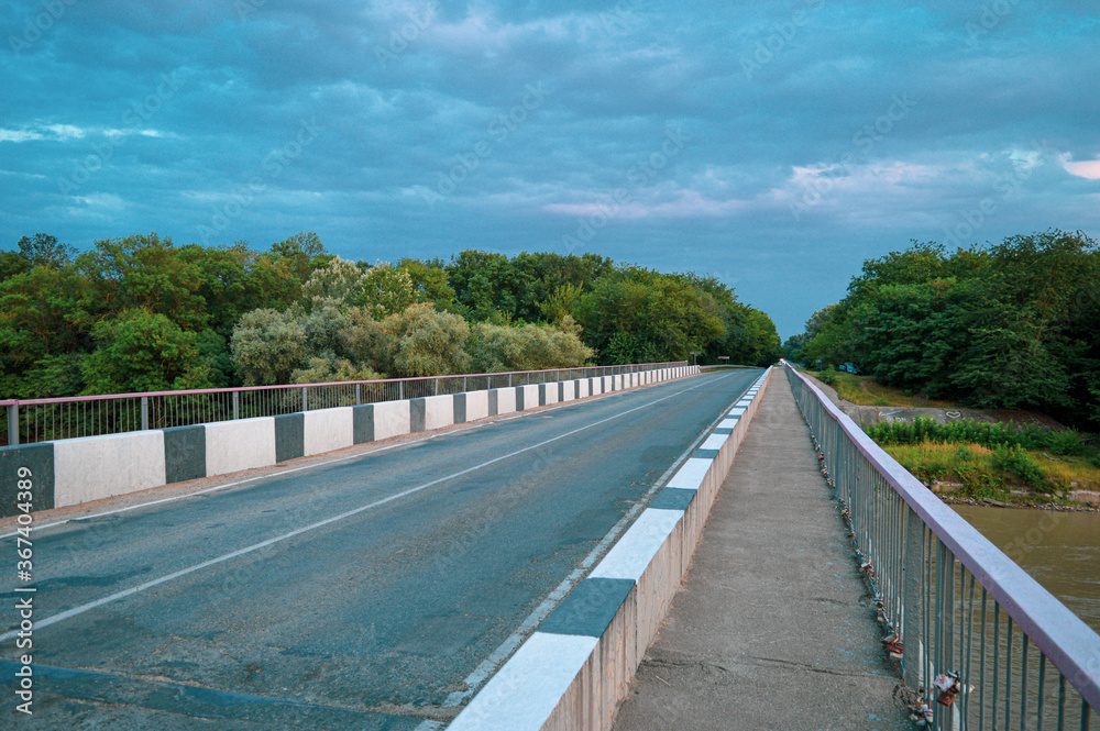 The bridge over the river on the background of turquoise sky