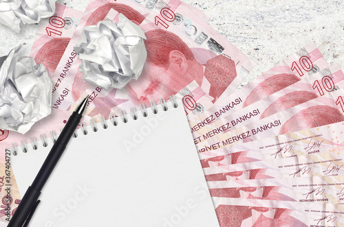 10 Turkish liras bills and balls of crumpled paper with blank notepad. Bad ideas or less of inspiration concept. Searching ideas for investment