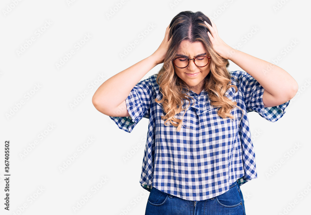 Young caucasian woman wearing casual clothes suffering from headache desperate and stressed because pain and migraine. hands on head. Young caucasian woman wearing casual clothes suffering from headache desperate and stressed because pain and migraine. hands on head.