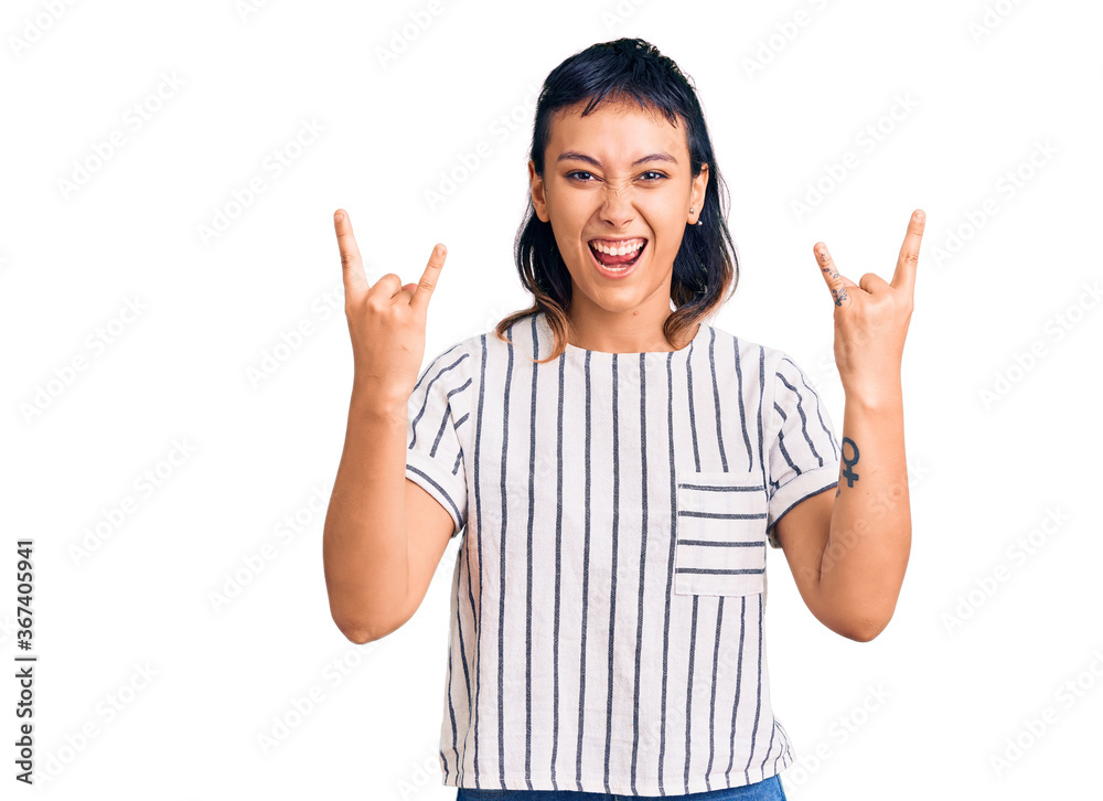 Young woman wearing casual clothes shouting with crazy expression doing rock symbol with hands up. music star. heavy music concept. Young woman wearing casual clothes shouting with crazy expression doing rock symbol with hands up. music star. heavy music concept.