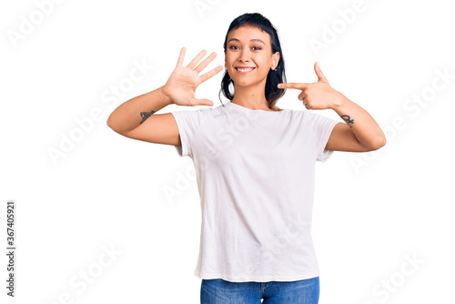 Young woman wearing casual clothes showing and pointing up with fingers number seven while smiling confident and happy.