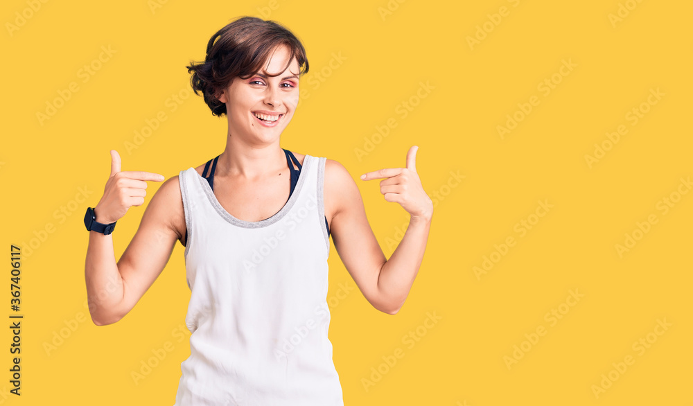 Beautiful young woman with short hair wearing casual sport clothes looking confident with smile on face, pointing oneself with fingers proud and happy. Beautiful young woman with short hair wearing casual sport clothes looking confident with smile on face, pointing oneself with fingers proud and happy.