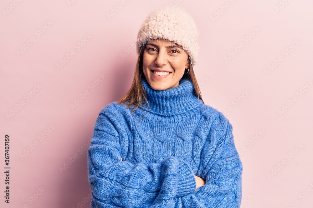 Young beautiful woman wearing winter clothes happy face smiling with crossed arms looking at the camera. positive person. Young beautiful woman wearing winter clothes happy face smiling with crossed arms looking at the camera. positive person.