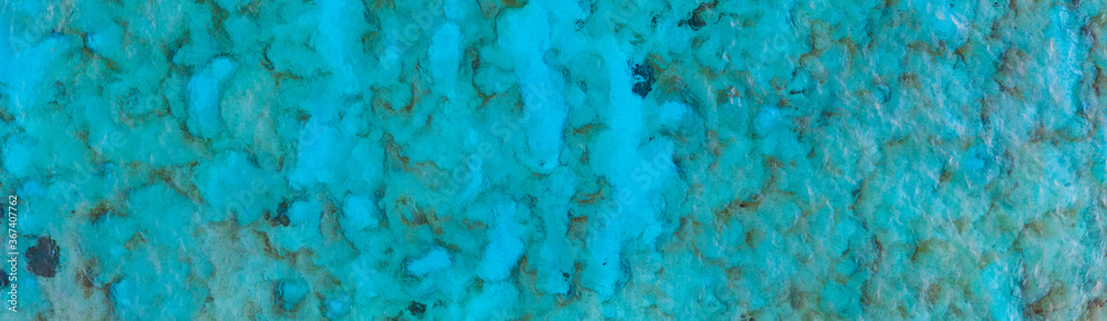 An aerial view of the beautiful Mediterranean sea, where you can se the rocky textured underwater corals and the clean turquoise water of Cyprus