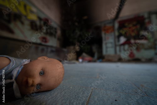 A vintage doll abandoned in the rooms of an abandoned psychiatric facility