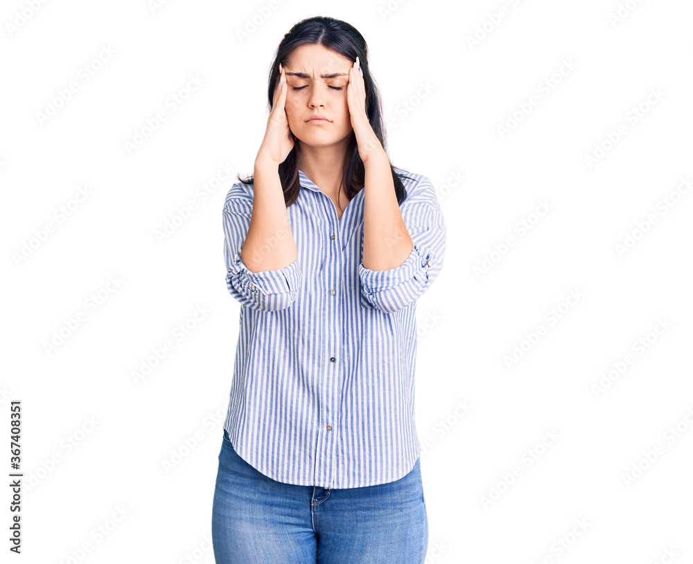 Young beautiful girl wearing striped shirt suffering from headache desperate and stressed because pain and migraine. hands on head. Young beautiful girl wearing striped shirt suffering from headache desperate and stressed because pain and migraine. hands on head.