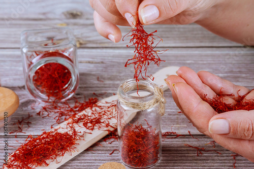 Fotografie The girl puts the saffron in a glass container