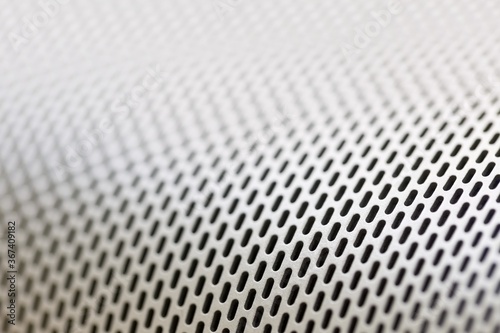 Abstract background macro shot of shiny aluminium metal sheet with holes