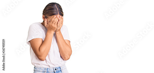 Young beautiful blonde woman wearing casual white tshirt with sad expression covering face with hands while crying. depression concept. photo