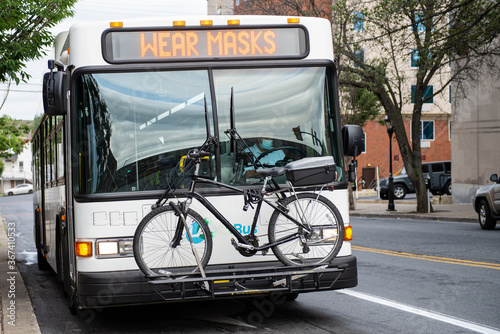 Bus with Wear Masks on destination area with a bike on the front.