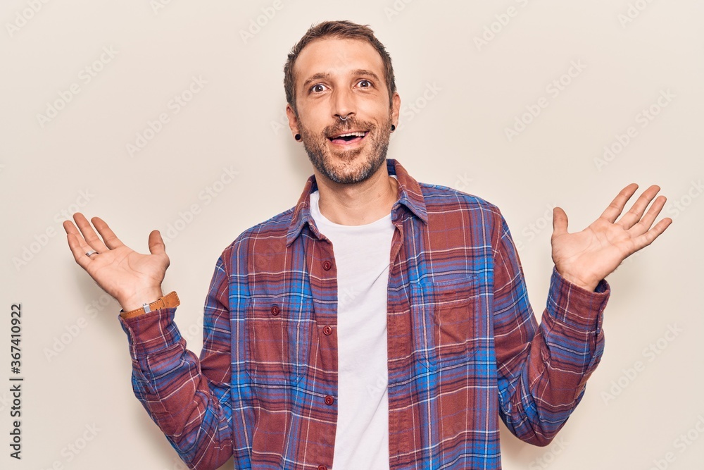 Young handsome man wearing casual clothes celebrating victory with happy smile and winner expression with raised hands Young handsome man wearing casual clothes celebrating victory with happy smile and winner expression with raised hands