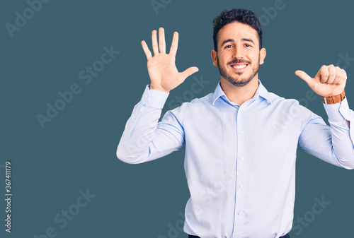Young hispanic man wearing business clothes showing and pointing up with fingers number six while smiling confident and happy. © Krakenimages.com