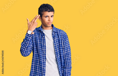 Canvas Print Young african amercian man wearing casual clothes shooting and killing oneself pointing hand and fingers to head like gun, suicide gesture