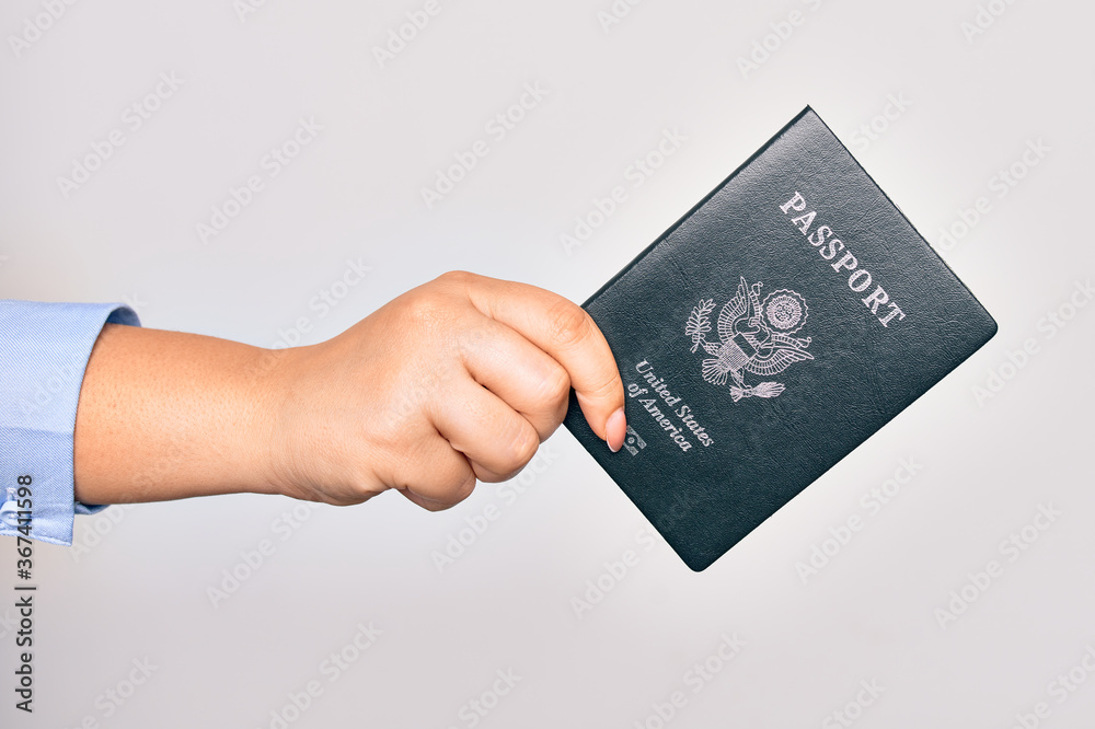 Hand of caucasian young woman holding united states passport document over isolated white background Hand of caucasian young woman holding united states passport document over isolated white background