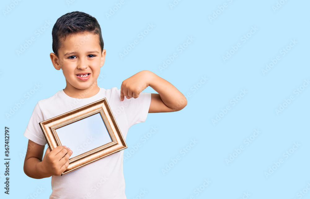 Little cute boy kid holding empty frame pointing finger to one self smiling happy and proud Little cute boy kid holding empty frame pointing finger to one self smiling happy and proud
