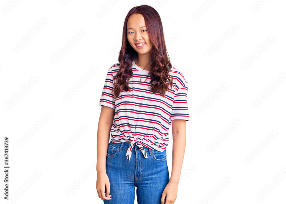 Young beautiful chinese girl wearing casual clothes looking positive and happy standing and smiling with a confident smile showing teeth Young beautiful chinese girl wearing casual clothes looking positive and happy standing and smiling with a confident smile showing teeth