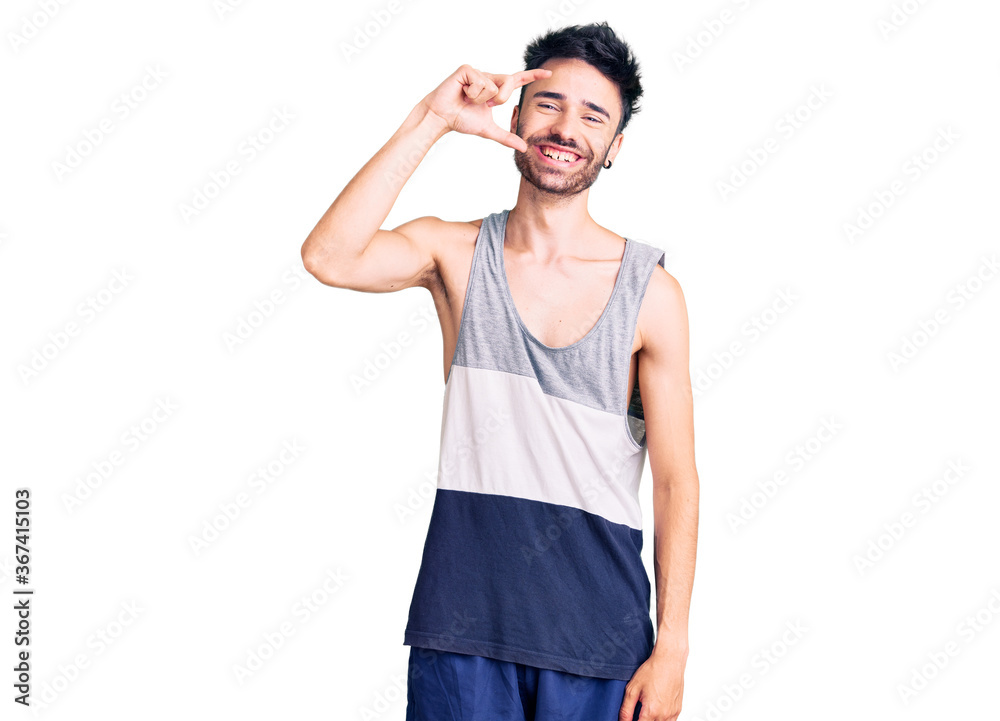 Young hispanic man wearing casual clothes smiling and confident gesturing with hand doing small size sign with fingers looking and the camera. measure concept. Young hispanic man wearing casual clothes smiling and confident gesturing with hand doing small size sign with fingers looking and the camera. measure concept.