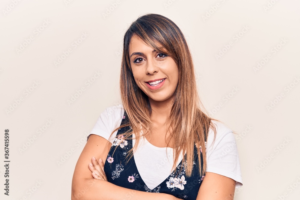 Young beautiful woman wearing casual floral dress happy face smiling with crossed arms looking at the camera. positive person. Young beautiful woman wearing casual floral dress happy face smiling with crossed arms looking at the camera. positive person.