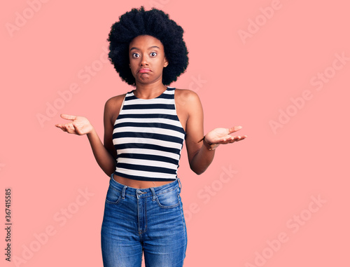 Young african american woman wearing casual clothes clueless and confused expression with arms and hands raised. doubt concept.