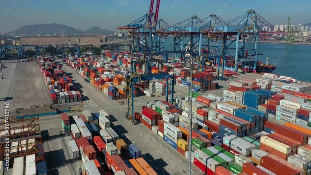 aerial view from busy industrial port with crane and containers from above. It is an import and export cargo port where is a part of shipping dock
