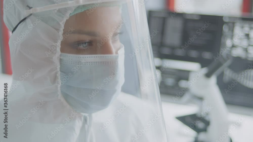 A female doctor portrait wearing a full protection suite in the modern laboratory. A female doctor portrait wearing a full protection suite in the modern laboratory.