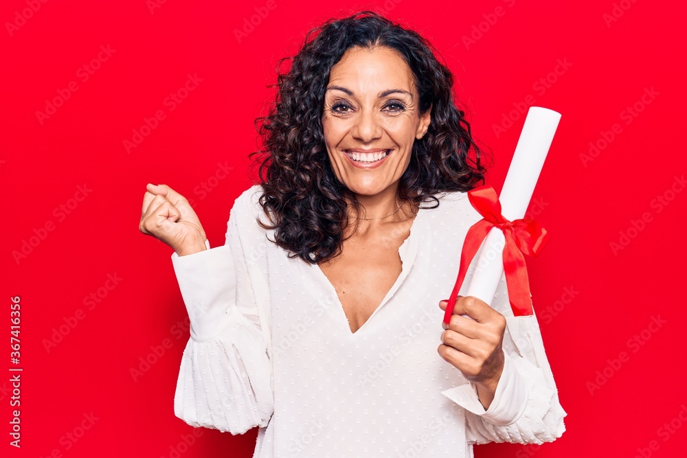 Middle age beautiful woman holding graduate degree diploma screaming proud, celebrating victory and success very excited with raised arm Middle age beautiful woman holding graduate degree diploma screaming proud, celebrating victory and success very excited with raised arm