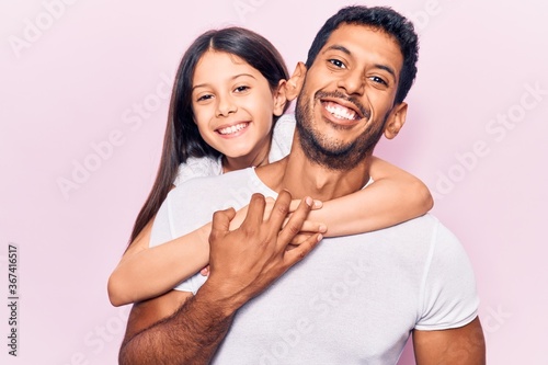 Hispanic young family of father and daughter hugging together with love