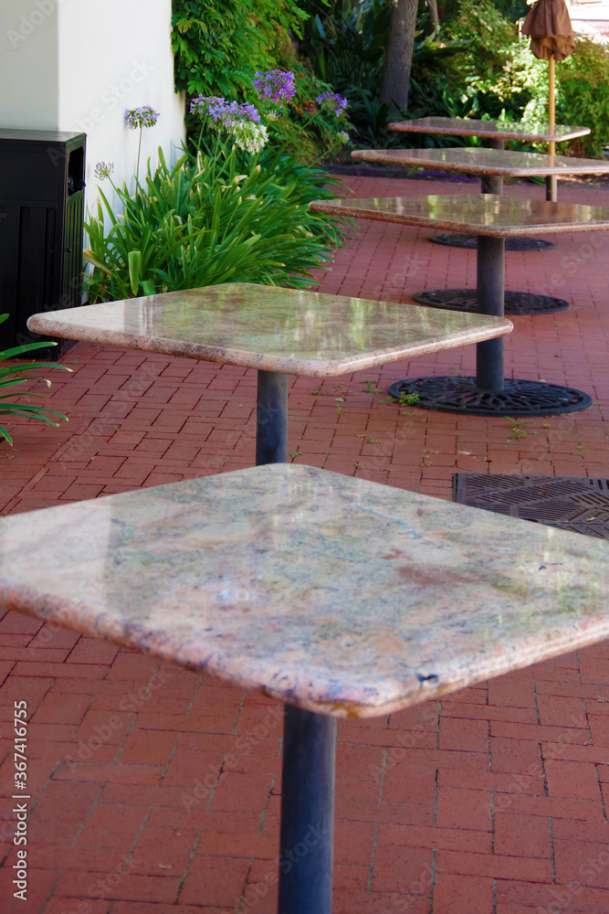 Empty and unused bistro tables on a restaurant patio which closed their business because of the coronavirus pandemic Empty and unused bistro tables on a restaurant patio which closed their business because of the coronavirus pandemic