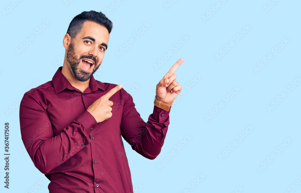Young hispanic man wearing casual clothes smiling and looking at the camera pointing with two hands and fingers to the side. Young hispanic man wearing casual clothes smiling and looking at the camera pointing with two hands and fingers to the side.