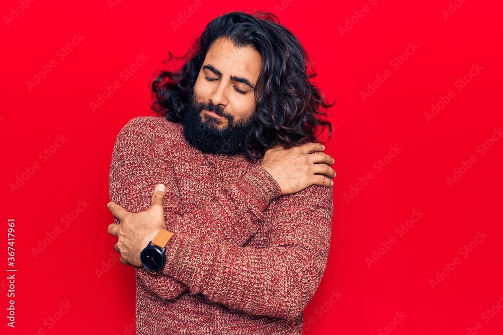 Young arab man wearing casual clothes hugging oneself happy and positive, smiling confident. self love and self care Young arab man wearing casual clothes hugging oneself happy and positive, smiling confident. self love and self care