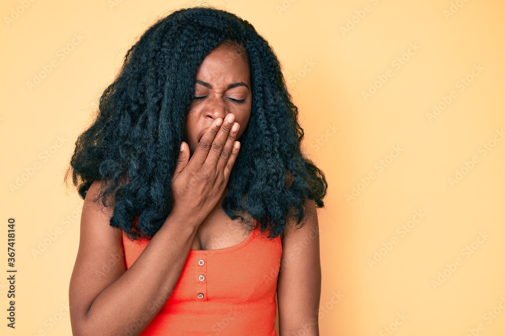 Beautiful african woman wearing casual clothes bored yawning tired covering mouth with hand. restless and sleepiness. Beautiful african woman wearing casual clothes bored yawning tired covering mouth with hand. restless and sleepiness.