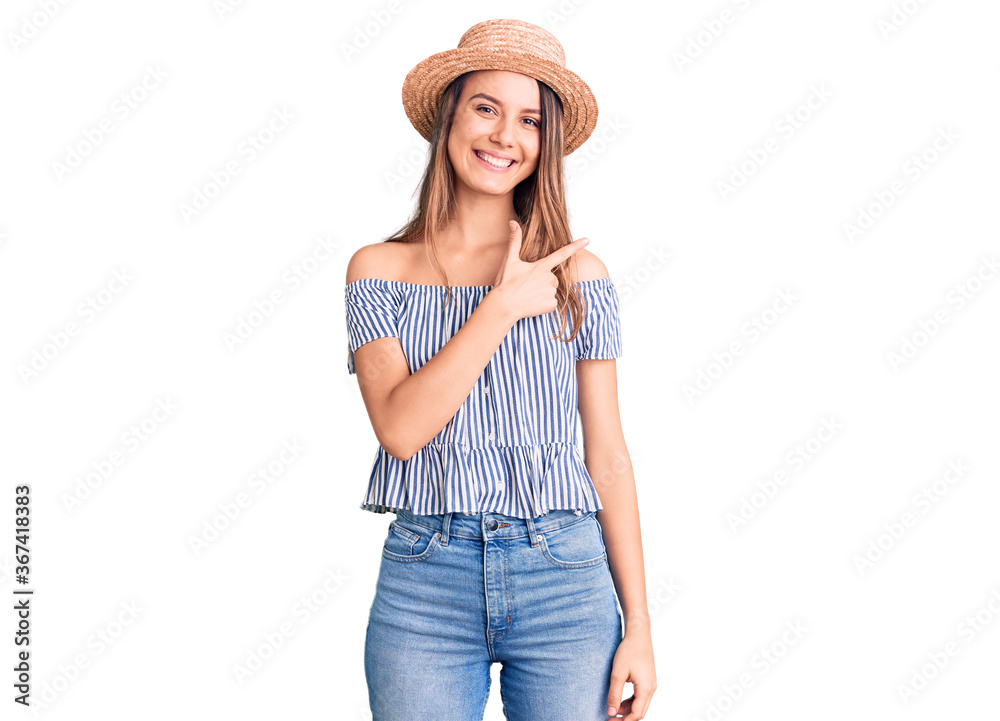 Young beautiful girl wearing hat and t shirt cheerful with a smile of face pointing with hand and finger up to the side with happy and natural expression on face Young beautiful girl wearing hat and t shirt cheerful with a smile of face pointing with hand and finger up to the side with happy and natural expression on face