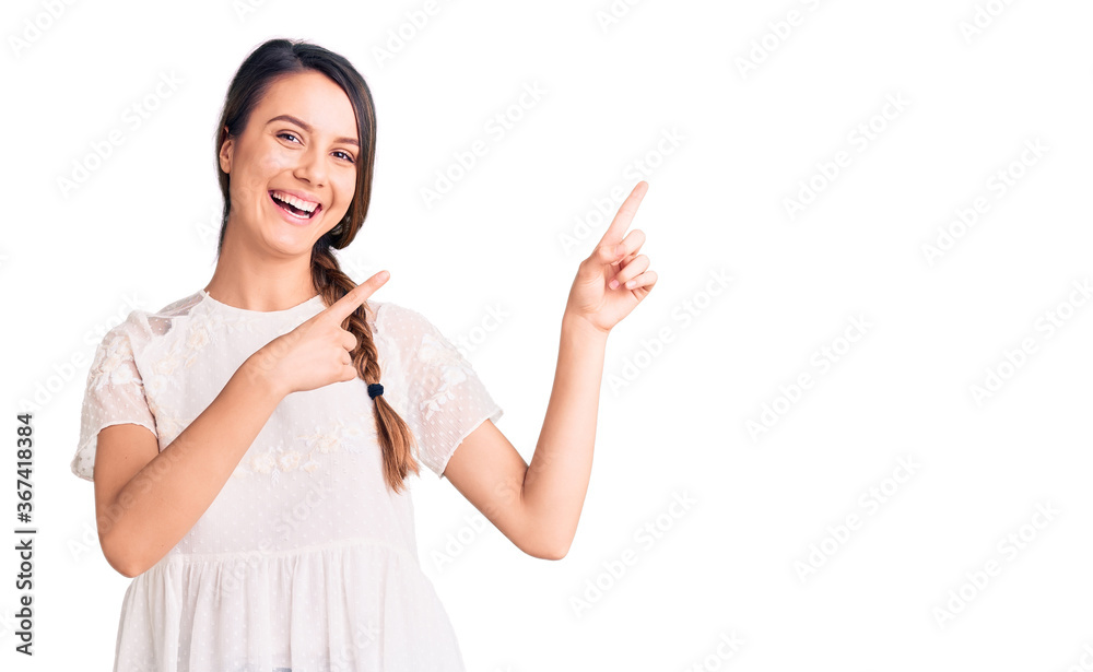 Young beautiful girl wearing casual t shirt smiling and looking at the camera pointing with two hands and fingers to the side. Young beautiful girl wearing casual t shirt smiling and looking at the camera pointing with two hands and fingers to the side.