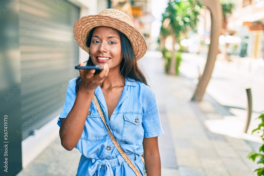 Young indian woman smiling happy using smartphone at the city