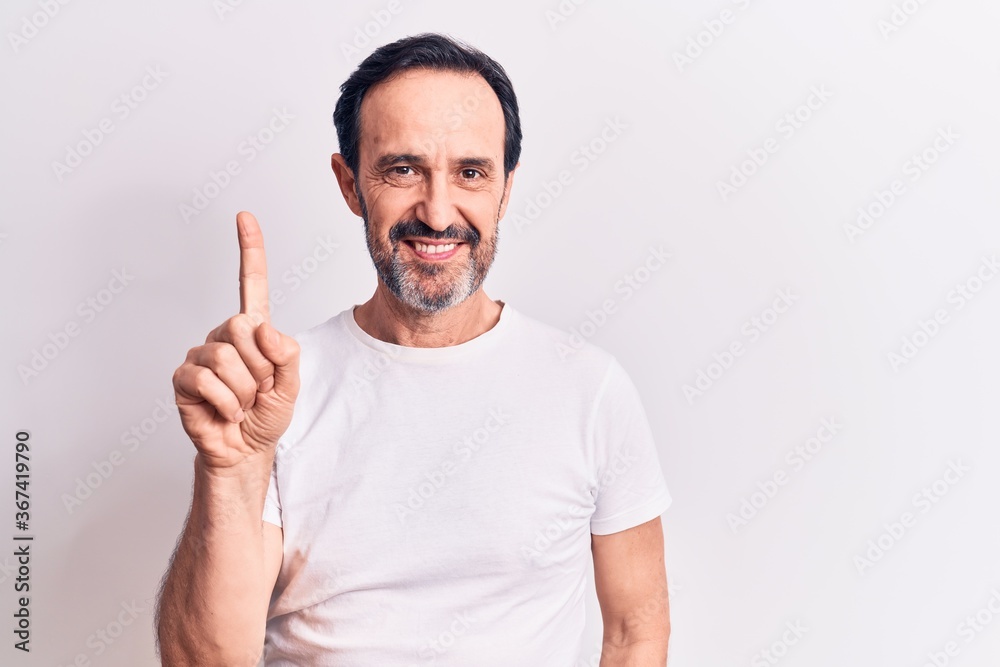 Middle age handsome man wearing casual t-shirt standing over isolated white background smiling with an idea or question pointing finger up with happy face, number one Middle age handsome man wearing casual t-shirt standing over isolated white background smiling with an idea or question pointing finger up with happy face, number one